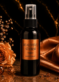 Bottle of 'Beautiful Storm' body spray with a rose and satin fabric on a dark background
