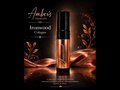 A bottle of Amber's Naturals Ironwood Cologne stands upright on a reflective surface against a dark background with warm copper-toned fabric and decorative leaf graphics. The bottle has a black cap and a metallic copper body with the brand name written in white script.