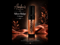 A bottle of Amber's Naturals Silver Ridge Cologne stands upright on a reflective surface against a dark background with warm copper-toned decorative leaves and draped fabric. The brand text 'Amber's Naturals' and product name 'Silver Ridge Cologne' appear above.