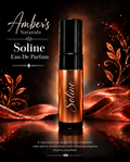 A perfume rollerball bottle labeled 'Soline' by Amber's Naturals, set against a dark background with glowing amber liquid, red-orange decorative leaves, and elegant white typography.