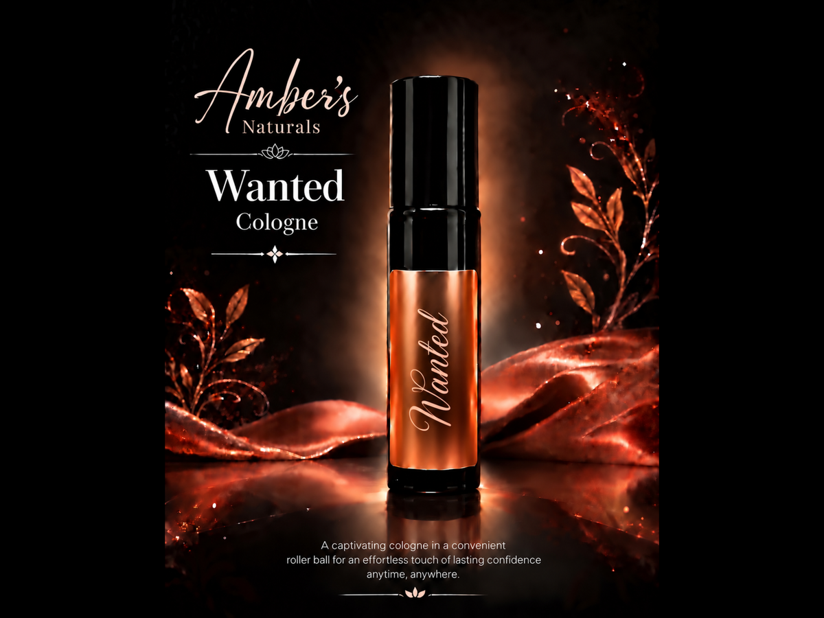 A cosmetic rollerball bottle labeled 'Wanted' by Amber's Naturals, shown against a dark background with warm copper and gold decorative leaves and draped fabric.